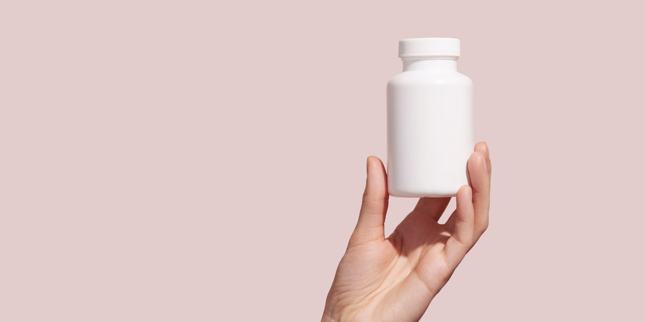 Holding vitamin supplement bottle