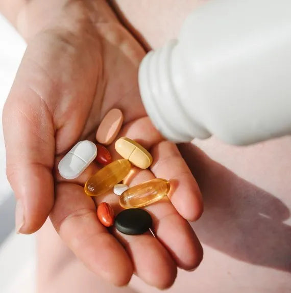 TrustWorks vitamin manufacturer holding vitamins tablets and softgels in hand
